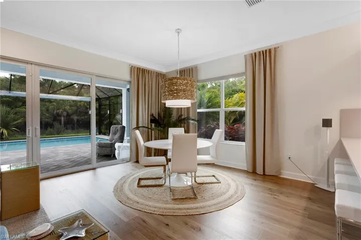 Dining area with wood finished floors, crown molding, and baseboards