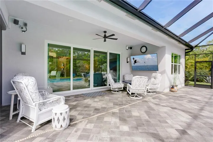 View of patio with ceiling fan and a lanai