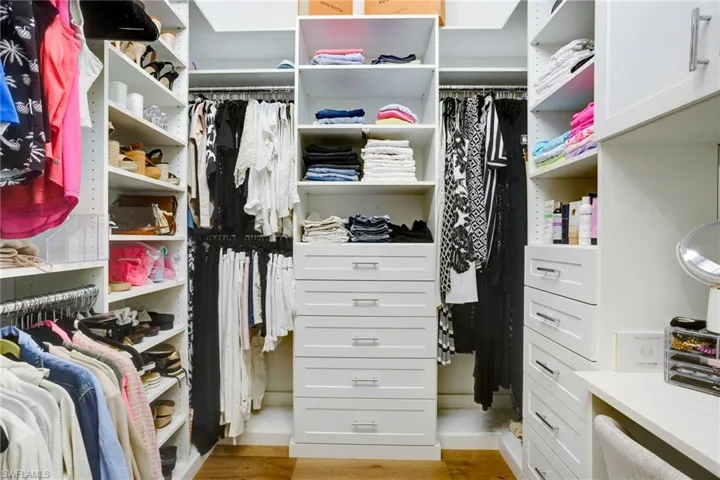 Walk in closet with light wood-type flooring