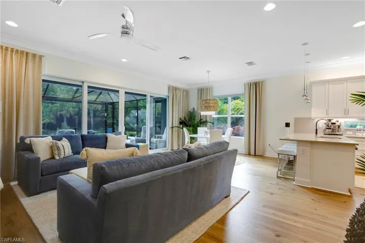 Living room with ceiling fan, recessed lighting, light wood-type flooring, ornamental molding, and a sunroom