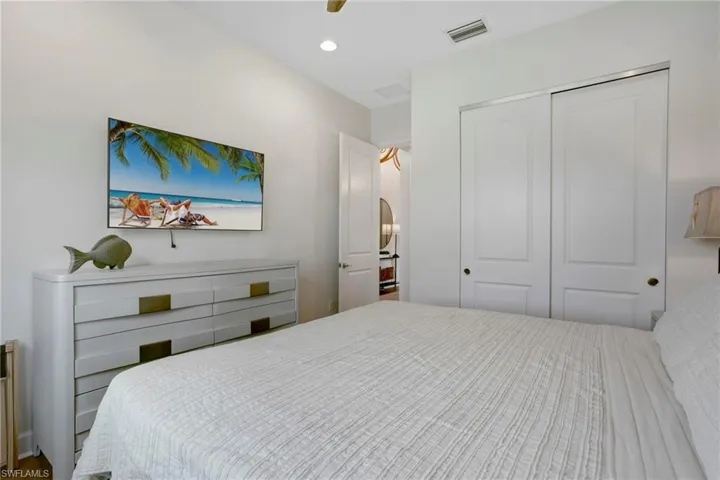 Bedroom with a closet, arched walkways, ceiling fan, and recessed lighting