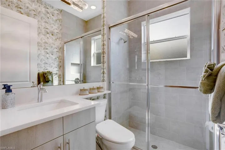 Full bathroom with vanity, toilet, and a shower stall