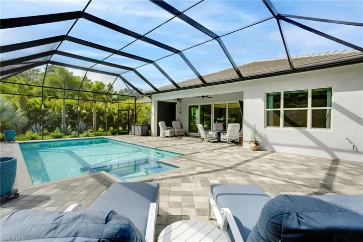 View of swimming pool with ceiling fan, a pool with connected hot tub, and a patio
