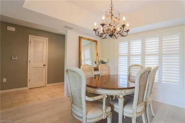 Dining room with light wood finished floors and a chandelier