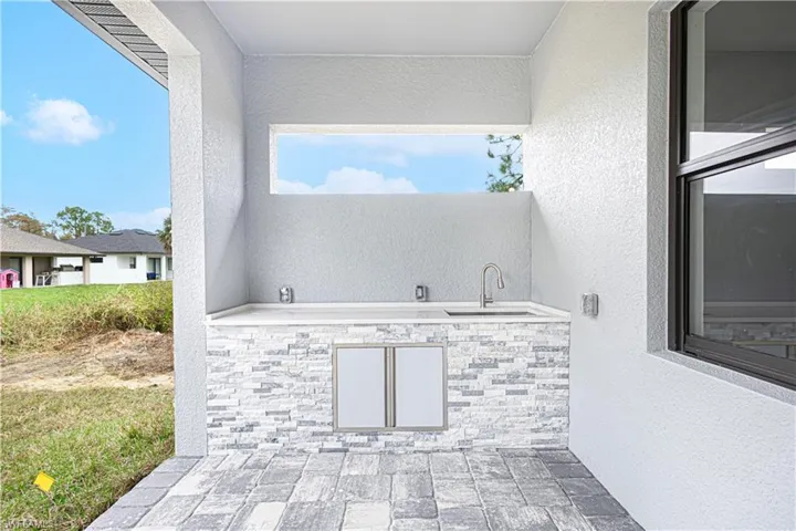 Outdoor kitchen area featuring a countertop, sink, and stainless steel cabinet doors