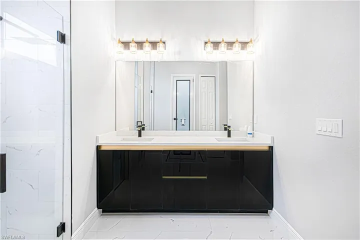Bathroom featuring a double vanity with a black cabinet, white countertops, and dual rectangular sinks