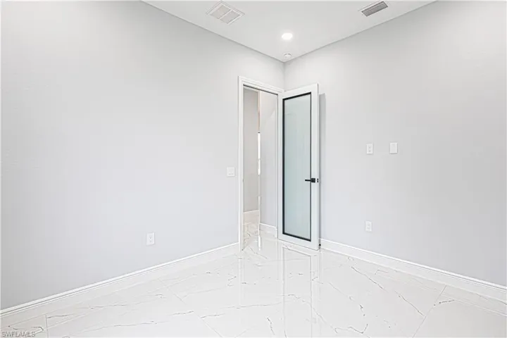 This room features light-colored walls and polished tile flooring