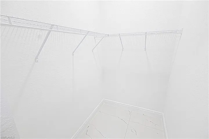 The property features a closet with white wire shelving and a tiled floor
