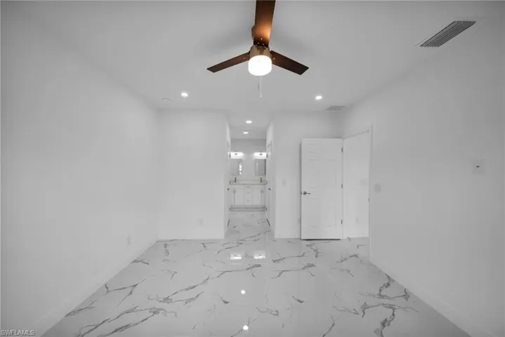 Spare room featuring a ceiling fan, light marble finish floors, and recessed lighting