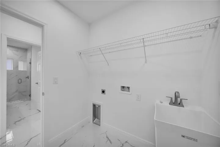 Laundry area featuring marble look tile flooring, hookup for an electric dryer, and washer hookup
