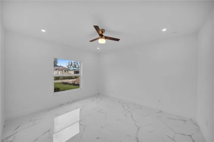 Empty room featuring recessed lighting, marble finish flooring, and a ceiling fan