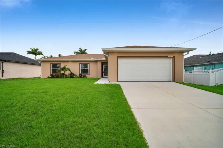 Single story home with stucco siding, a garage, and driveway
