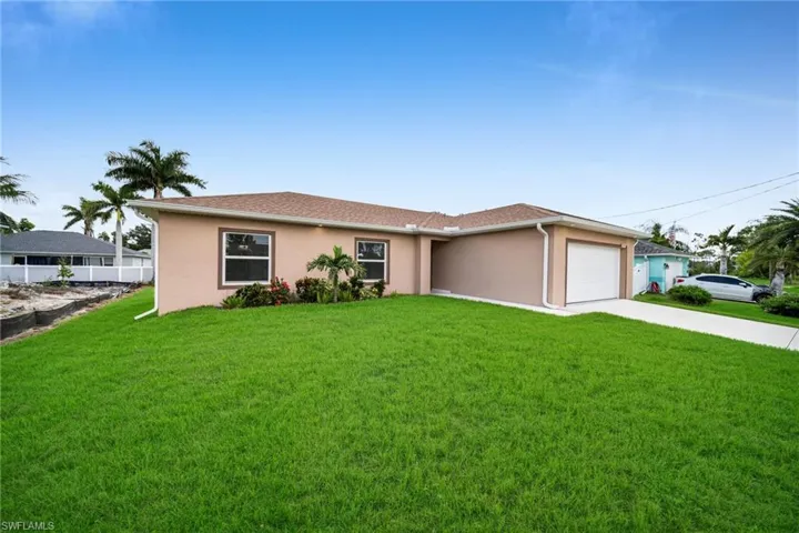 Ranch-style house featuring stucco siding, an attached garage, and driveway