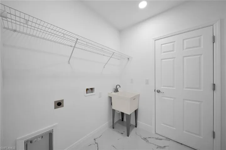 Laundry room with hookup for an electric dryer, washer hookup, light marble finish floors, and recessed lighting