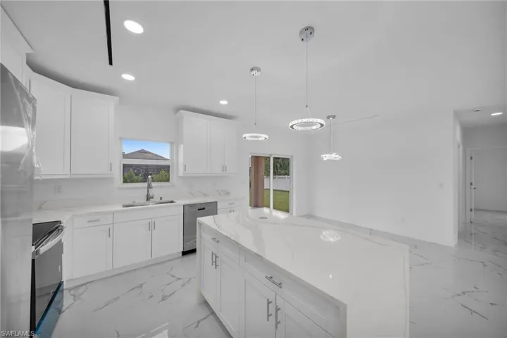 Kitchen featuring appliances with stainless steel finishes, light marble finish flooring, plenty of natural light, and recessed lighting