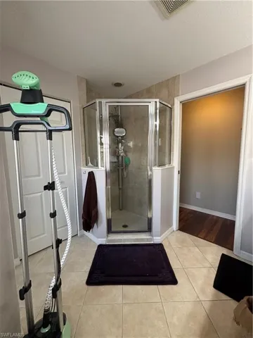 Bathroom featuring light tile patterned floors and a stall shower
