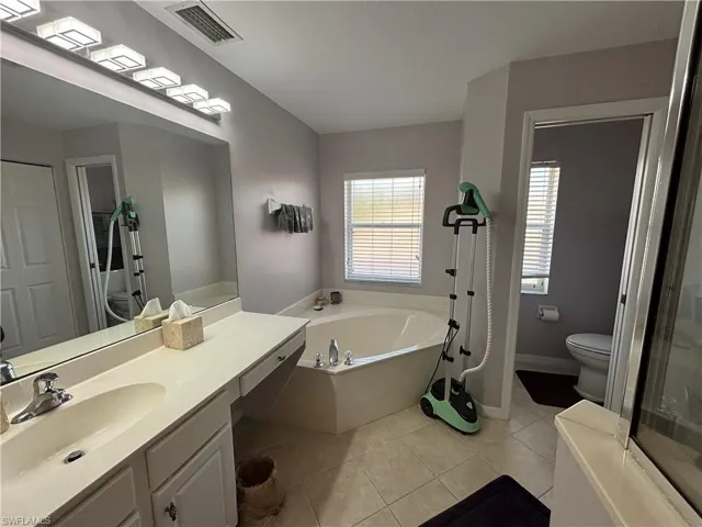 Full bathroom with a bath, vanity, and light tile patterned floors