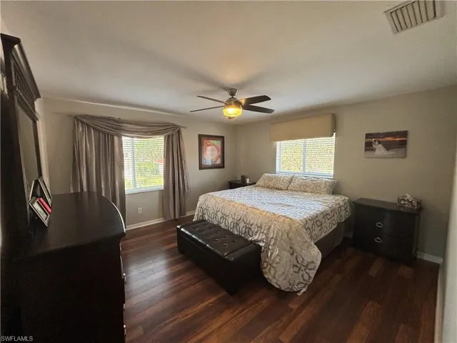 Bedroom with dark wood finished floors and ceiling fan