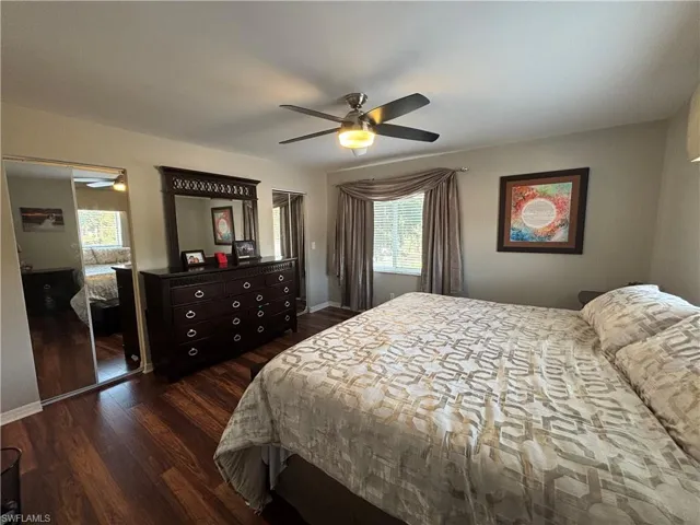 Bedroom with dark wood-style floors, a ceiling fan, and a closet