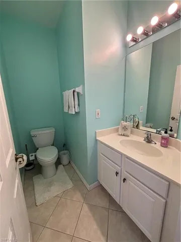 Half bathroom featuring vanity and light tile patterned floors