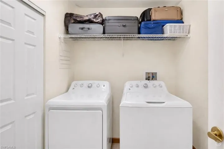 Dedicated laundry area featuring a white bi-fold door, a wire storage shelf, and light-colored walls