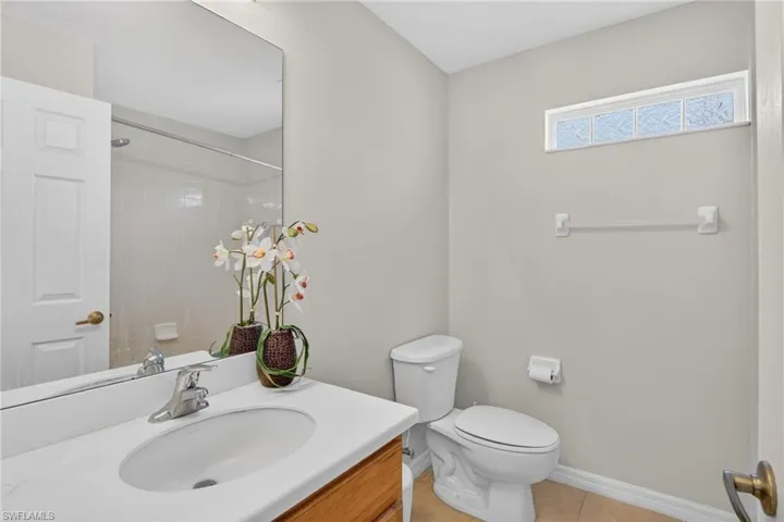 Bathroom with vanity, a shower, and light tile patterned floors