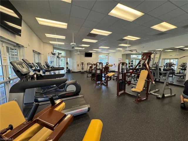 Gym with a drop ceiling and a ceiling fan