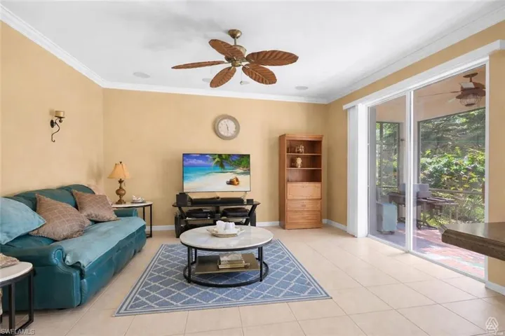 Spacious interior featuring tile flooring, crown molding, and a ceiling fan with leaf-shaped blades
