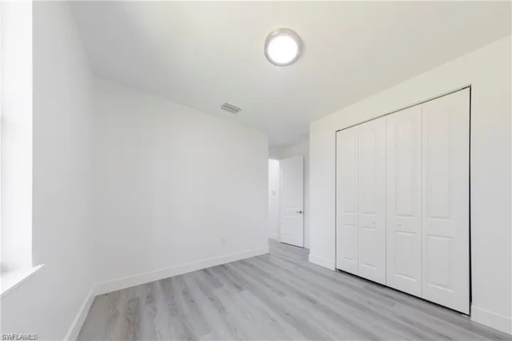 Unfurnished bedroom with light wood finished floors and a closet