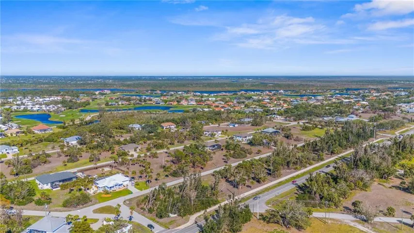 Aerial view of property's location with a large body of water and nearby suburban area