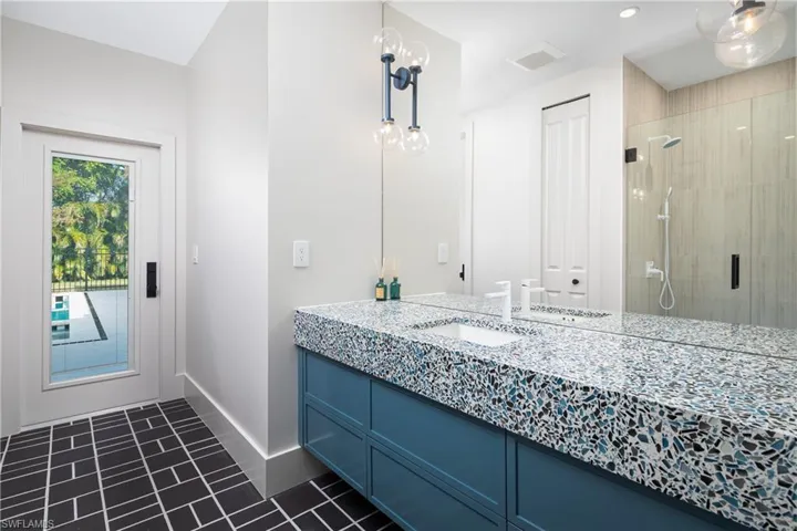 Bathroom featuring tile patterned flooring, vanity, and an enclosed shower