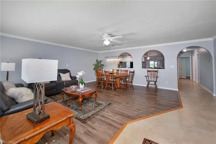 Living room featuring ceiling fan, ornamental molding, and hardwood / wood-style flooring