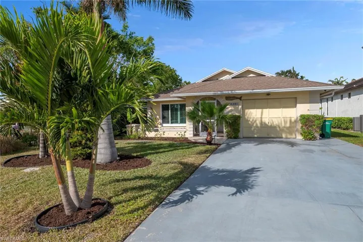View of front facade with a garage and a front lawn
