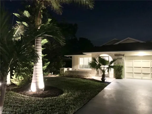View of front of home with a garage and a lawn