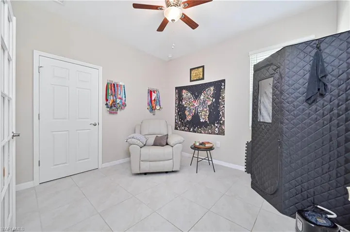 Sitting room with a ceiling fan and light tile patterned floors