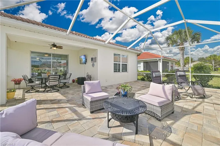 View of patio with a ceiling fan, a lanai, a sunroom, an outdoor living / dining area, and a fire pit