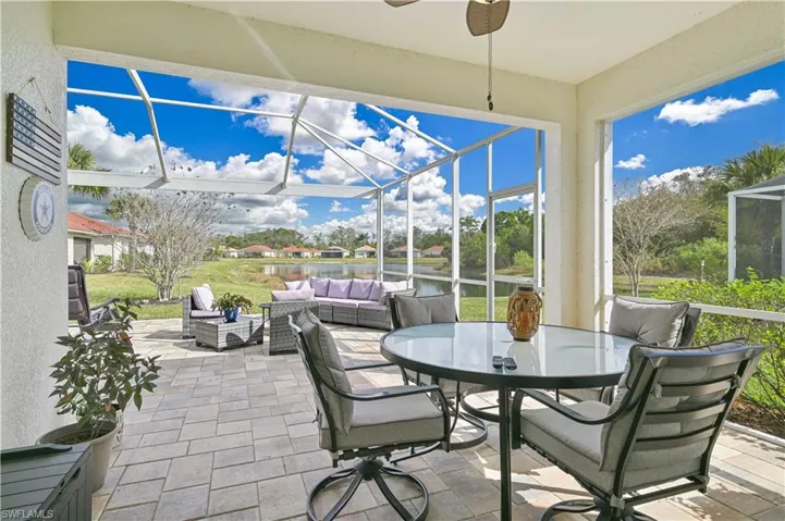 View of patio / terrace featuring glass enclosure, a sunroom, an outdoor living / dining area, a water view, and a residential view