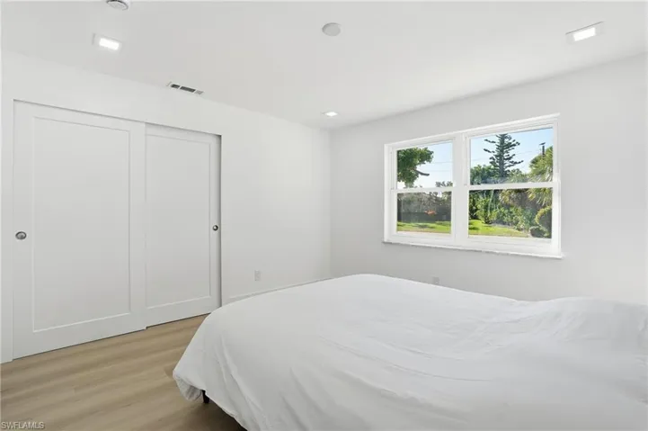 Spacious room featuring light wood-finish flooring, recessed lighting, and a double window
