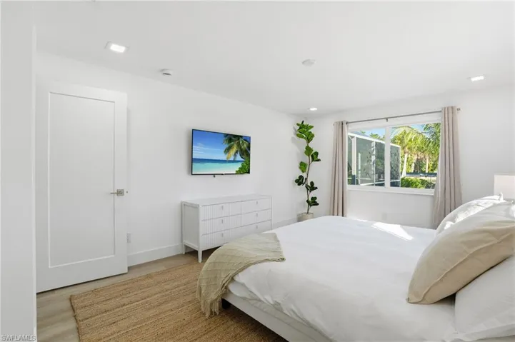 Bright room featuring a large window with exterior views, wood-finish flooring, recessed lighting, and a contemporary door