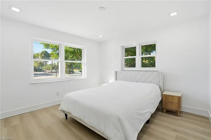 Bright interior featuring light wood-finish flooring, white walls, and recessed lighting