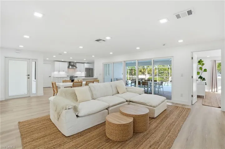 Bright open-concept living area featuring light wood-finish flooring and recessed lighting