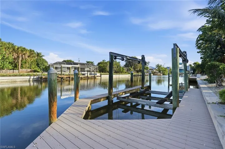 Waterfront property featuring a private boat dock with an integrated lift system, composite decking, and direct canal access