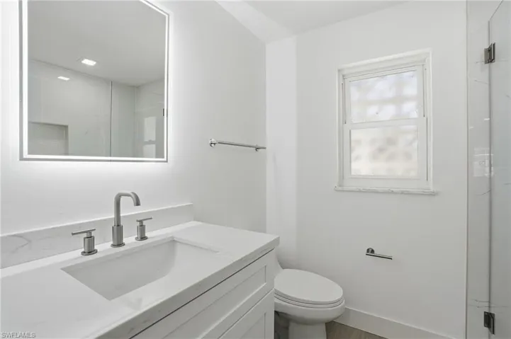 Modern vanity with an integrated rectangular sink, stone-finish countertop, and brushed nickel hardware