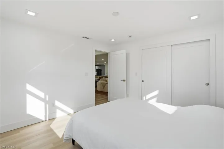 Bright interior featuring light wood-finish flooring, recessed lighting, and a white sliding closet door