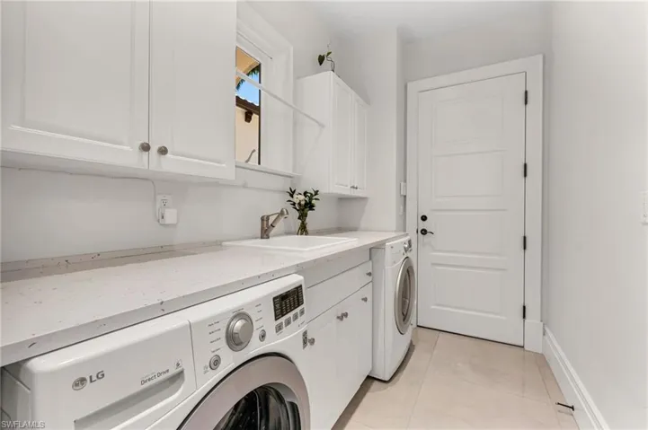 Laundry room has had a full remodel, with oversized washer and dryer and new flooring.