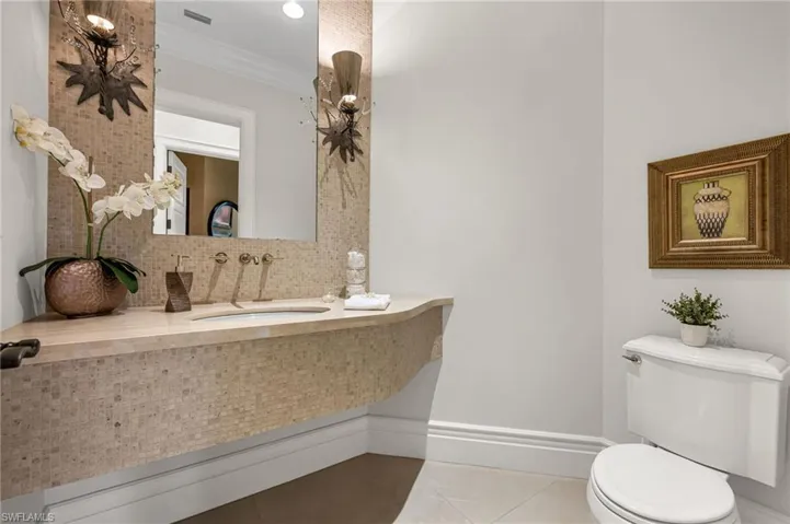 The guest powder bath has very custom, unique vanity and light fixtures.