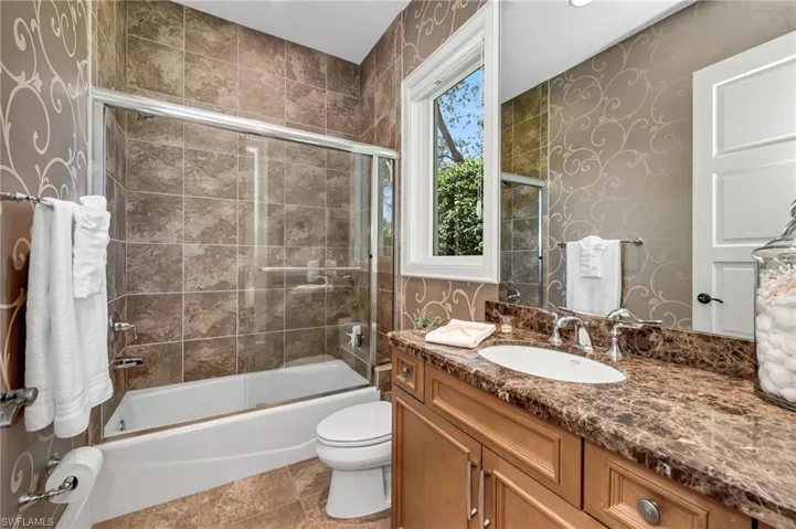 Guest bath with tub and shower and Emperador Dark marble counter.