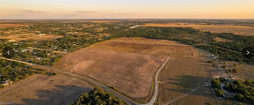 Expansive land parcel featuring a winding dirt road and surrounding natural vegetation