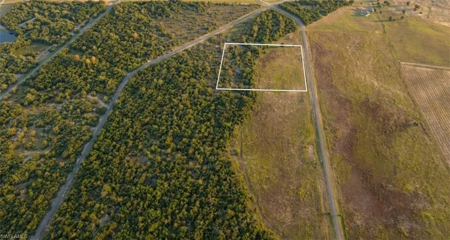 Expansive undeveloped land parcel featuring a mix of mature trees and open fields