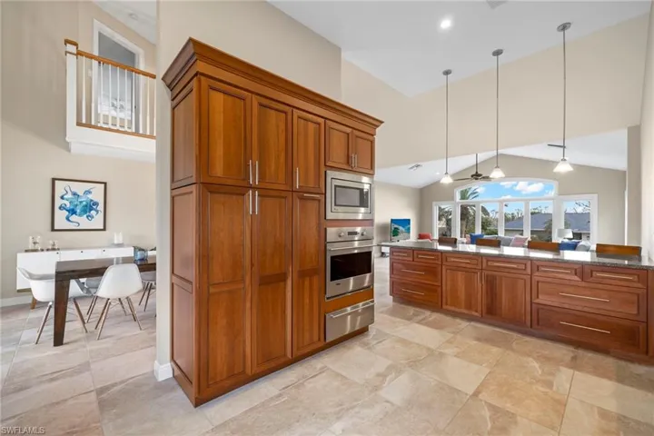 Kitchen with pendant lighting, stainless steel appliances, and high vaulted ceiling